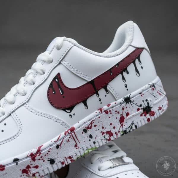 Custom hand-painted white Air Force 1 sneakers with blue splash and red Nike swoosh.