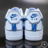 Pair of Nike Air sneakers in white and blue, perfect for casual and sportswear.