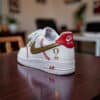 Custom baseball-themed Nike Air Force 1 sneakers with gold and red accents.