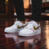 Custom baseball-themed Air Force 1 sneakers with gold swoosh and red stitching details.