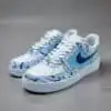 Air Force 1 sneakers with blue splash paint design, hand-painted for a unique look.