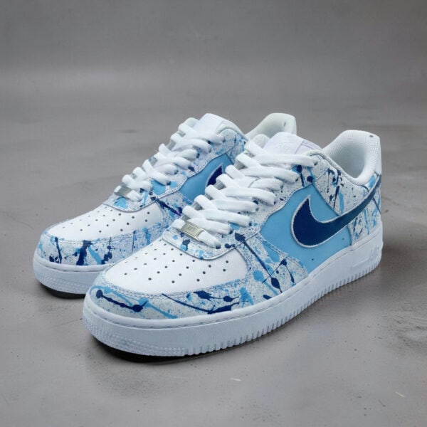 Air Force 1 sneakers with blue splash paint design, hand-painted for a unique look.
