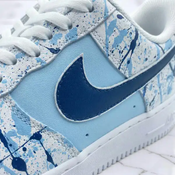 Hand-painted blue splash design on Air Force 1 sneaker with Nike swoosh.