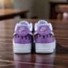 Hand-painted purple Ice Cream Drip Nike Air Force 1 sneakers on wooden table.