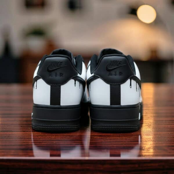 Custom white drip Air Force 1 sneakers with black accents and unique design details.
