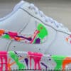 Custom painted Air Force 1 sneakers with vibrant splash art design. Unique hand-painted footwear for.