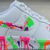Custom painted Air Force 1 sneakers with vibrant splash art design. Unique hand-painted footwear for.