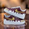 Custom AF1 sneakers with drip paint design and gold Nike swoosh for personalized footwear.