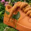 Hand-painted orange and green drip design on custom Air Force 1 sneakers. Unique, vibrant, and artis.