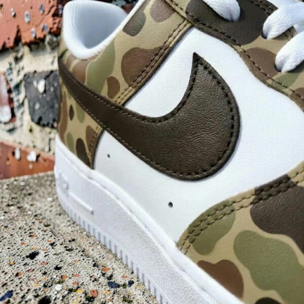 Custom painted camouflage Nike Air Force 1 sneakers with detailed design.