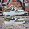 Camouflage Air Force 1 sneakers with hand-painted details and Nike swoosh. Unique streetwear footwea.