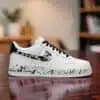 Custom hand-painted black splash design on white Air Force 1 sneakers.