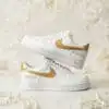 Custom hand-painted white Air Force 1 sneakers with gold accents for weddings.