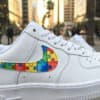 Custom hand-painted puzzle design on Air Force 1 sneakers for autism awareness.