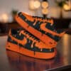 Hand-painted orange drip design on black Air Force 1 sneakers for a bold, artistic look.