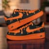 Custom orange drip Nike Air Force 1 sneakers with black accents and unique paint design.