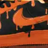 Custom orange drip Nike Air Force 1 sneakers with black accents and unique paint design.