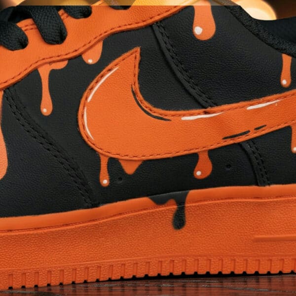 Custom orange drip Nike Air Force 1 sneakers with black accents and unique paint design.